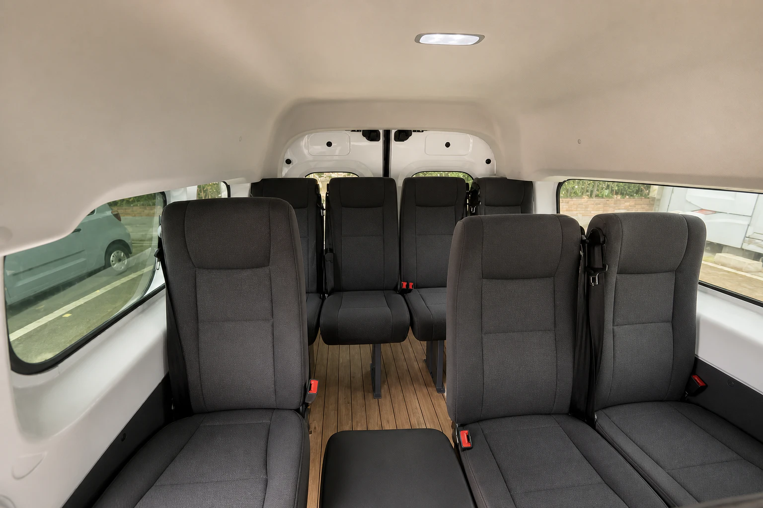 Dark grey passenger seats and a central aisle inside a CloudLines electric van